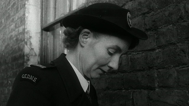 1952年，英国，Wadhurst，蒙太奇区护士从公寓里出来，把医疗包绑到自行车上，骑着车走过街道，路过在人行道上玩耍的孩子们视频素材画面4